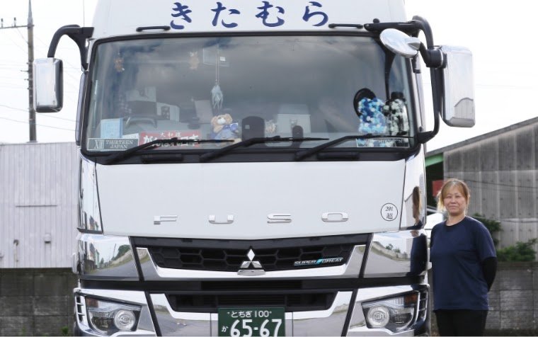 大型トラックの前に立つ当社のドライバー